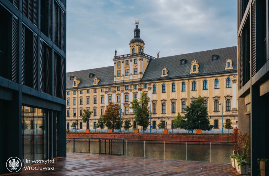 Widok na budynek Uniwersytetu Wrocławskiego i drzewa po drugiej stronie rzeki