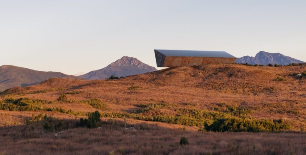 Wizualizacja monumentu w postaci pomarańczowej bryły położonej na rozległym pustym polu w Tasmanii