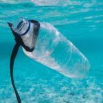 Plastikowa butelka pływająca pod wodą turkusowego oceanu