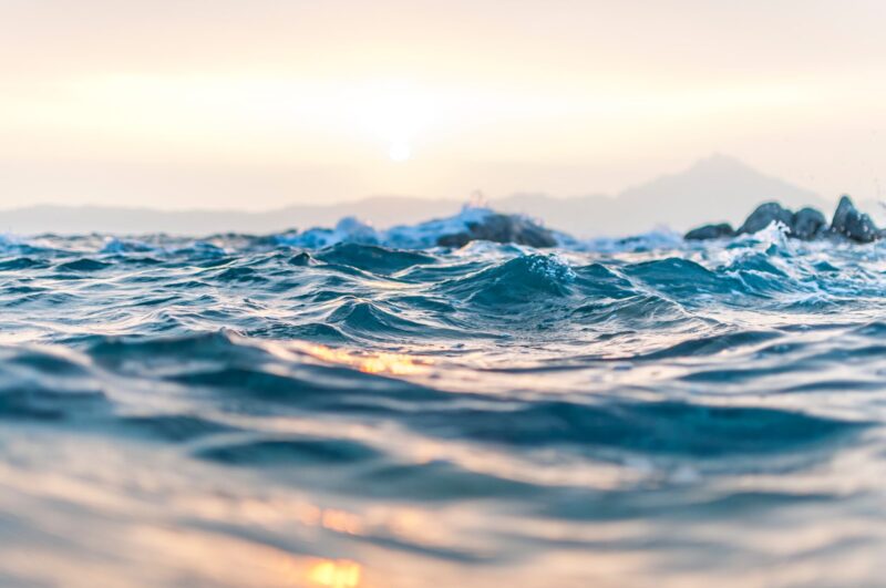 Widok na taflę wody oceanu o wschodzie słońca