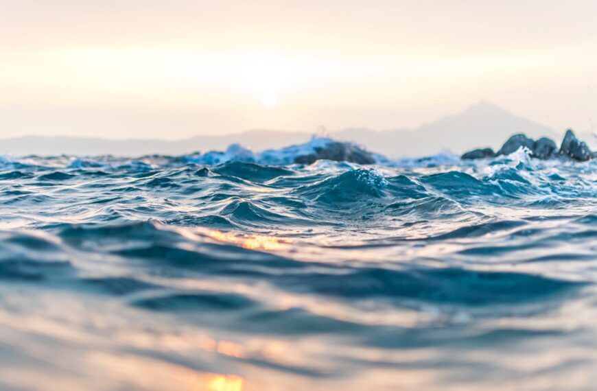 Widok na taflę wody oceanu o wschodzie słońca